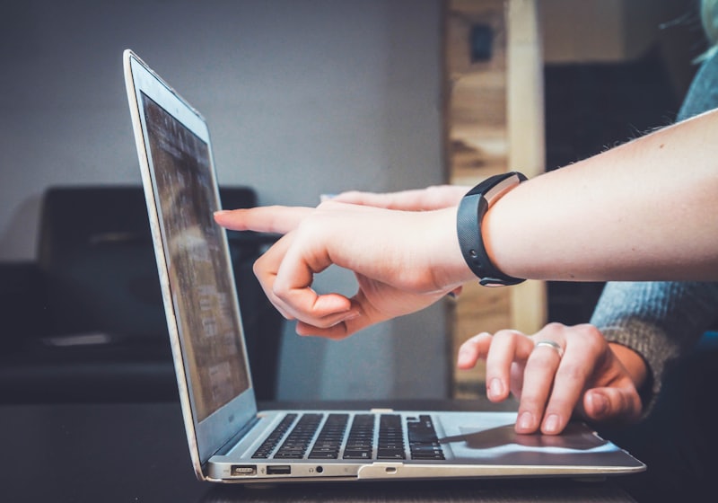 Two people looking at the same laptop screen